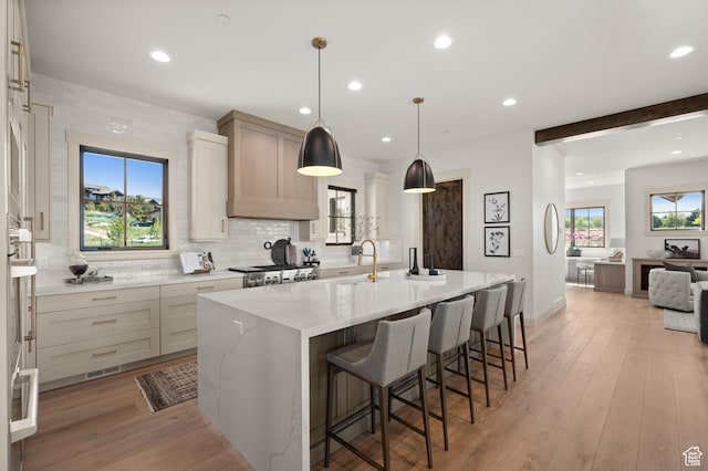 113 N Haystack Mountain Dr Unit 2, Heber City, UT 84032 - kitchen featuring a kitchen island with sink, backsplash, a sink, a kitchen bar, and light stone countertops