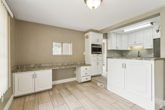 2937 S 900 E, Salt Lake City, UT 84106 - kitchen featuring stainless steel microwave, white cabinets, tasteful backsplash, baseboards, and a sink