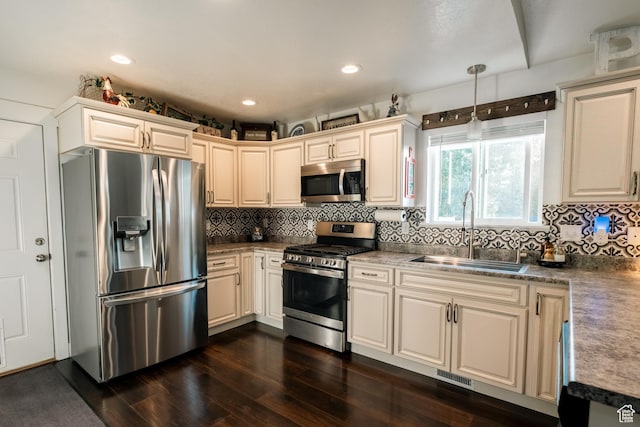 45 N Center St, Hyrum, UT 84319 - kitchen featuring appliances with stainless steel finishes, a sink, dark wood-style floors, decorative backsplash, and decorative light fixtures