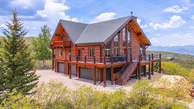 1551 Tree Top Ln Unit 360, Heber City, UT 84032 - rear view of house featuring log siding, a deck with mountain view, a garage, stairway, and a shingled roof