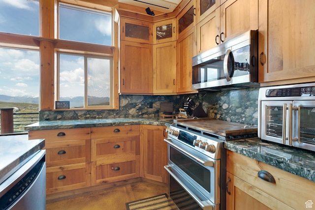 1551 Tree Top Ln Unit 360, Heber City, UT 84032 - kitchen with appliances with stainless steel finishes, backsplash, glass insert cabinets, concrete flooring, and a mountain view