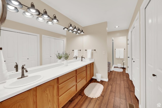1502 W Cornerstone Dr, South Jordan, UT 84095 - full bathroom with double vanity, a closet, wood finished floors, and baseboards