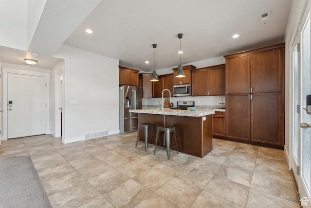 4269 S Haven Park Way, Holladay, UT 84124 - kitchen featuring stainless steel appliances, a kitchen island with sink, brown cabinetry, a kitchen bar, and recessed lighting