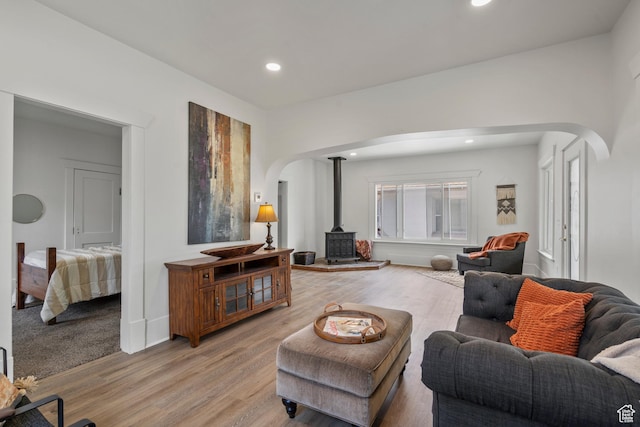 2955 S Jefferson Ave E, Ogden, UT 84403 - living area featuring arched walkways, a wood stove, light wood-type flooring, recessed lighting, and baseboards