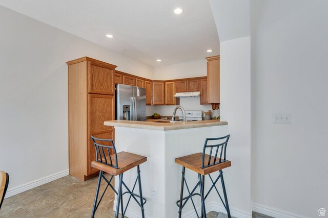 14069 S Rutherford Ave W, Bluffdale, UT 84065 - kitchen with stainless steel refrigerator with ice dispenser, under cabinet range hood, a kitchen bar, recessed lighting, and a peninsula