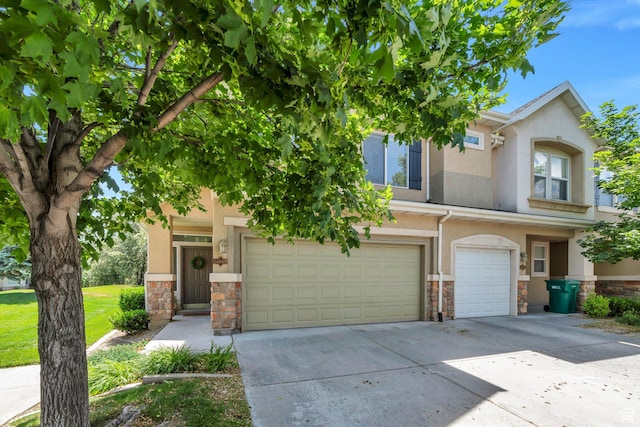 14069 S Rutherford Ave W, Bluffdale, UT 84065 - townhome / multi-family property with stone siding, a garage, concrete driveway, and stucco siding