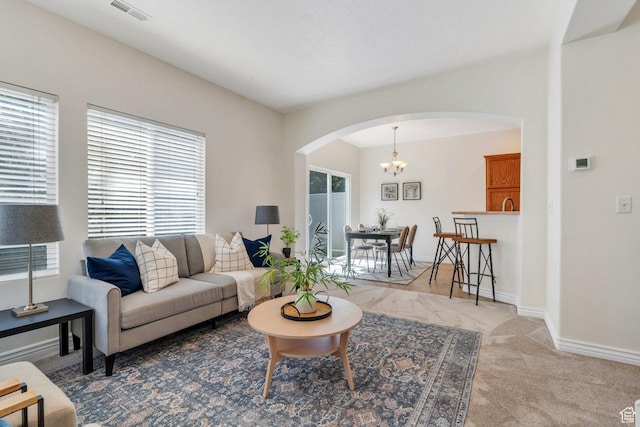 14069 S Rutherford Ave W, Bluffdale, UT 84065 - carpeted living room with arched walkways, a chandelier, and baseboards