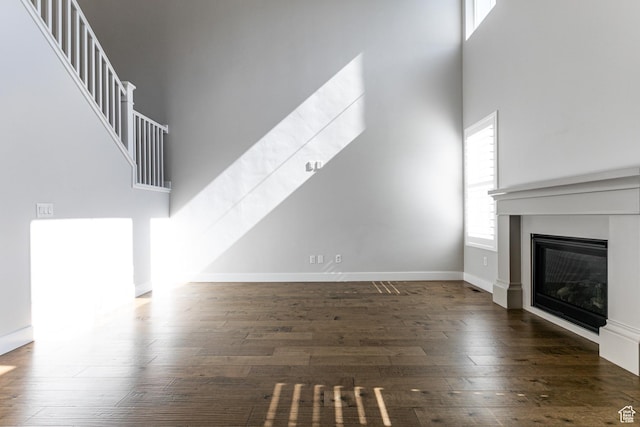 1065 S 425 W, Farmington, UT 84025 - unfurnished living room with a towering ceiling, a glass covered fireplace, wood finished floors, and baseboards