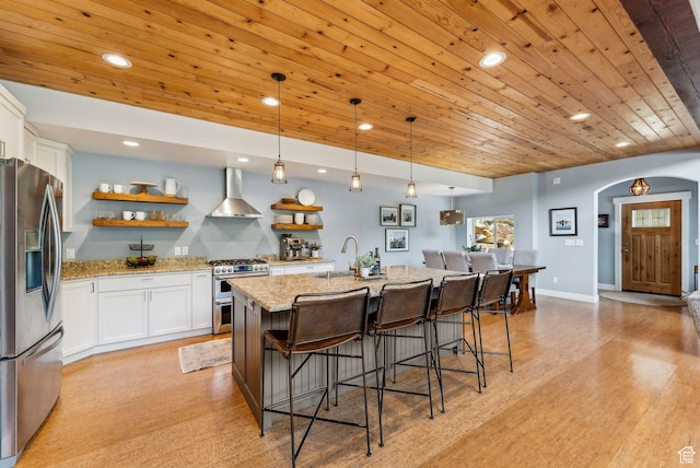 705 Parkview Dr, Summit Park, UT 84098 - kitchen featuring stainless steel appliances, wall chimney exhaust hood, a sink, open shelves, and arched walkways
