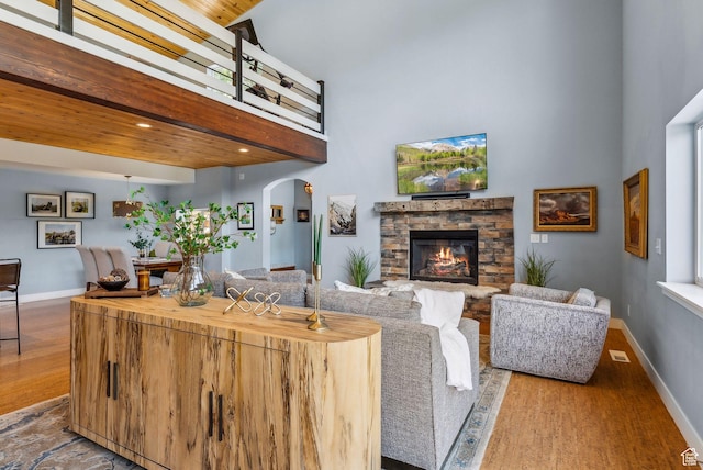 705 Parkview Dr, Summit Park, UT 84098 - living room featuring a high ceiling, arched walkways, wood finished floors, a fireplace, and baseboards