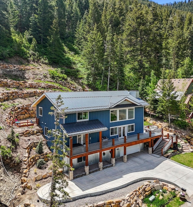 705 Parkview Dr, Summit Park, UT 84098 - rustic home with a wooded view, concrete driveway, metal roof, an attached garage, and stairway