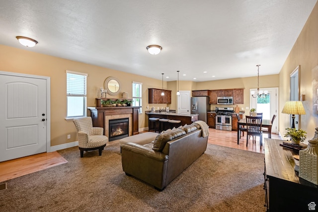 658 S 150 E, Smithfield, UT 84335 - living room featuring carpet, plenty of natural light, a tiled fireplace, and a chandelier