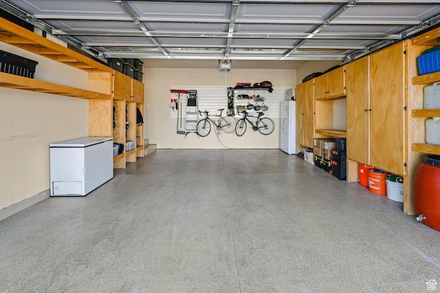 658 S 150 E, Smithfield, UT 84335 - garage with white fridge, a garage door opener, and washer / dryer