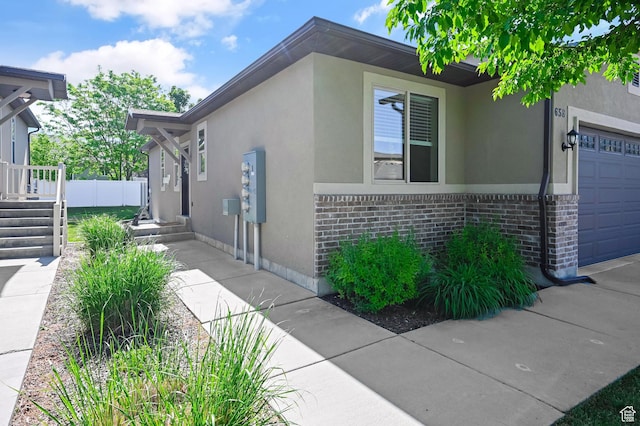658 S 150 E, Smithfield, UT 84335 - view of property exterior featuring stucco siding, brick siding, and an attached garage