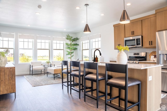 7017 W S Jordan Pkwy, South Jordan, UT 84009 - kitchen with stainless steel appliances, wood finished floors, recessed lighting, backsplash, and brown cabinets