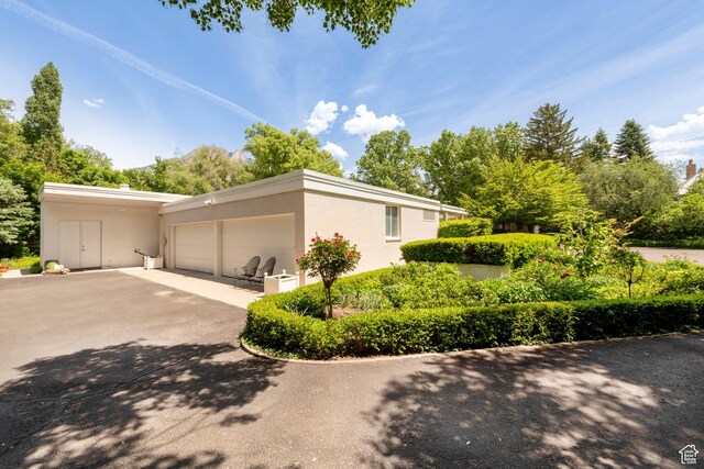2285 E Cottonwood Cir, Holladay, UT 84117 - view of side of property featuring driveway, a garage, and stucco siding