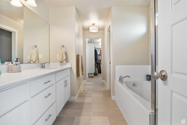 1295 E Granite Peak Rd, Eagle Mountain, UT 84005 - full bathroom with vanity, a bath, a spacious closet, and baseboards