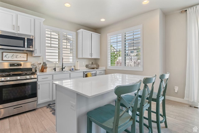 1295 E Granite Peak Rd, Eagle Mountain, UT 84005 - kitchen with appliances with stainless steel finishes, a sink, light countertops, light wood-style floors, and recessed lighting
