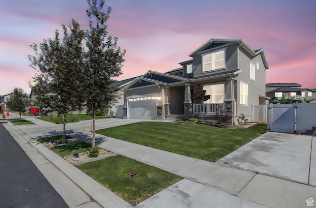 1295 E Granite Peak Rd, Eagle Mountain, UT 84005 - view of front of house with a gate, covered porch, concrete driveway, stucco siding, and an attached garage
