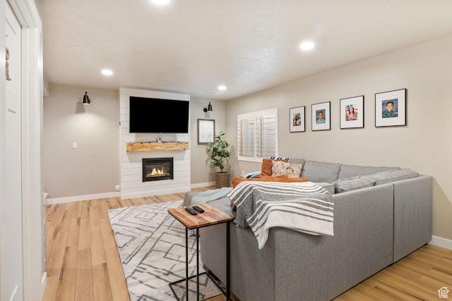 1295 E Granite Peak Rd, Eagle Mountain, UT 84005 - living area featuring a large fireplace, light wood-style flooring, recessed lighting, and baseboards