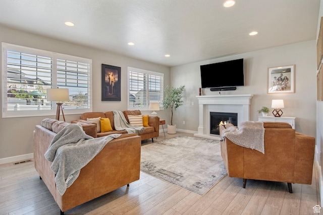1295 E Granite Peak Rd, Eagle Mountain, UT 84005 - living room featuring light wood-style flooring, a glass covered fireplace, recessed lighting, and baseboards