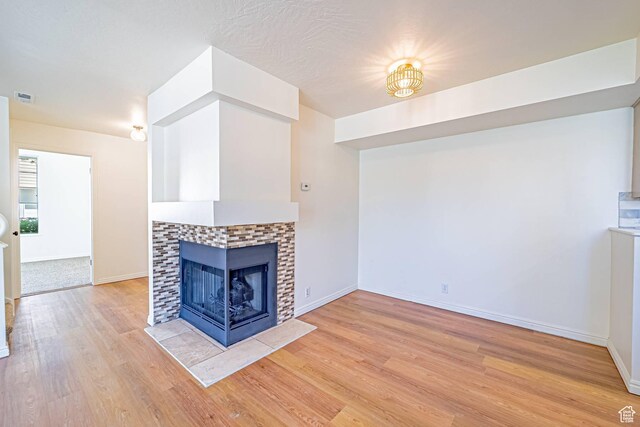 5457 S Break Water Dr W, Taylorsville, UT 84123 - unfurnished living room featuring light wood-type flooring, baseboards, and a fireplace
