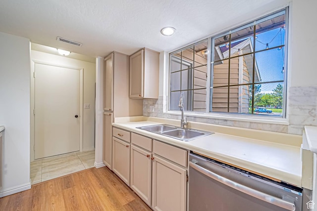 5457 S Break Water Dr W, Taylorsville, UT 84123 - kitchen featuring stainless steel dishwasher, a sink, light countertops, light wood-style floors, and a textured ceiling