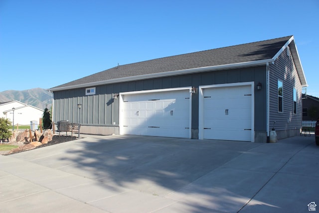 730 S 300 W, Garland, UT 84312 - view of front of house featuring board and batten siding, a garage, a mountain view, concrete driveway, and roof with shingles