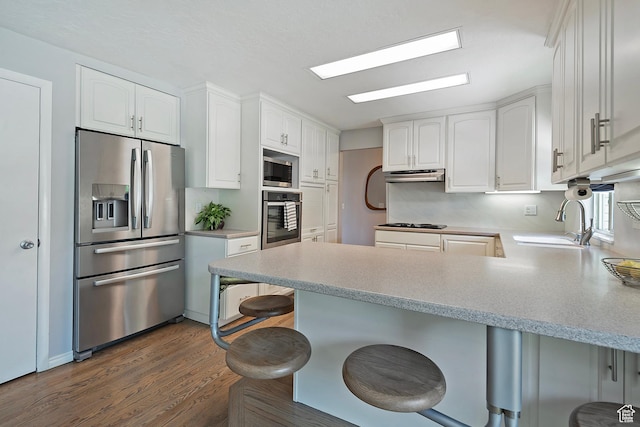 96 S 350 E, North Salt Lake, UT 84054 - kitchen featuring stainless steel appliances, a peninsula, a sink, under cabinet range hood, and white cabinetry