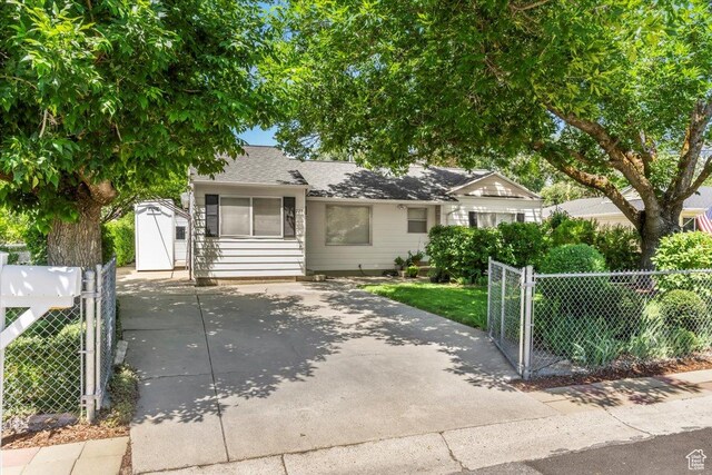 223 W Glen Pl N, Layton, UT 84041 - view of front of house featuring a gate, driveway, a shingled roof, and a storage unit