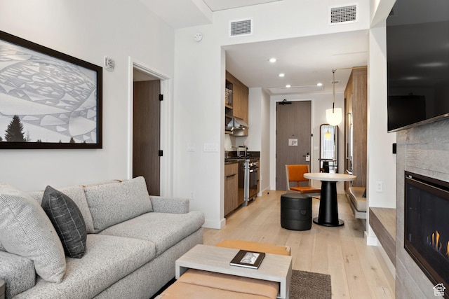 2417 W High Rd Unit 1504, Park City, UT 84098 - living area featuring light wood-style floors, a glass covered fireplace, recessed lighting, and baseboards