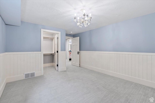 3 Dawn Hill Dr, Sandy, UT 84092 - unfurnished room with carpet, a wainscoted wall, a chandelier, and a textured ceiling