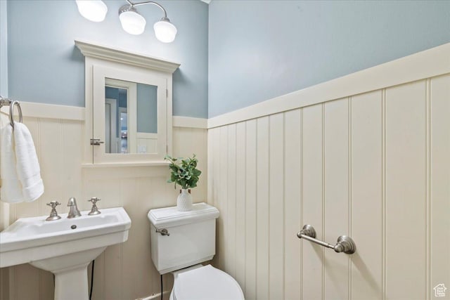 3 Dawn Hill Dr, Sandy, UT 84092 - half bathroom featuring toilet, wainscoting, a decorative wall, and a sink