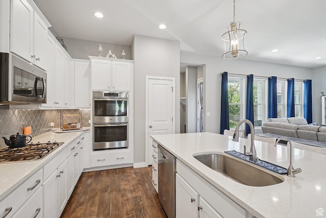 4411 W S Jordan Pkwy, South Jordan, UT 84009 - kitchen with stainless steel appliances, a sink, dark wood-style floors, tasteful backsplash, and white cabinetry
