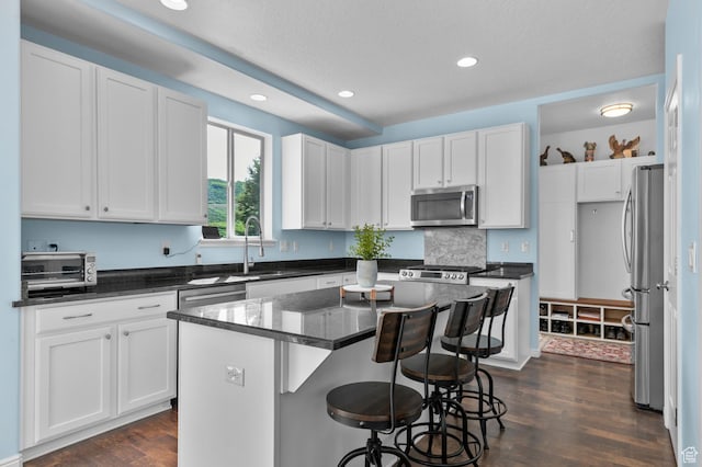 14585 S Delacroix Dr S, Draper, UT 84020 - kitchen with appliances with stainless steel finishes, dark wood finished floors, a center island, white cabinetry, and recessed lighting