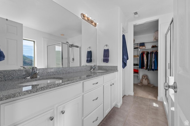 14585 S Delacroix Dr S, Draper, UT 84020 - bathroom with a stall shower, double vanity, a walk in closet, and tile patterned floors