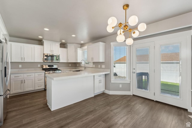 1184 S 2300 E, Spanish Fork, UT 84660 - kitchen with stainless steel appliances, light countertops, a peninsula, dark wood-style flooring, and white cabinetry