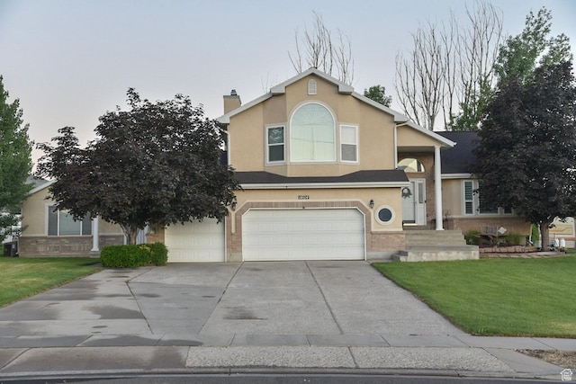14114 S 3600 W, Bluffdale, UT 84065 - view of front of home featuring a garage, driveway, a front yard, stucco siding, and a chimney