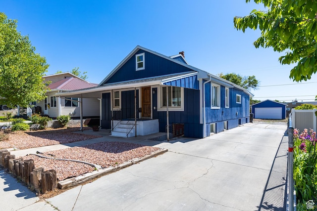 824 N 200 E, Price, UT 84501 - view of front facade featuring covered porch, driveway, board and batten siding, an outdoor structure, and a garage