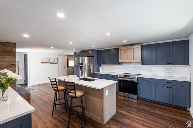 824 N 200 E, Price, UT 84501 - kitchen with stainless steel appliances, a breakfast bar area, tasteful backsplash, dark wood finished floors, and a kitchen island with sink