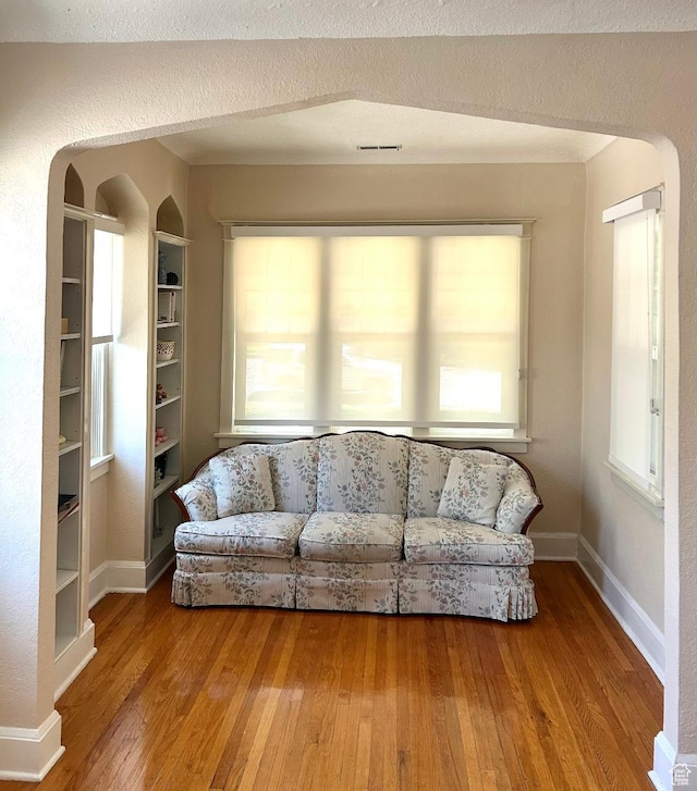734 S 1300 E, Salt Lake City, UT 84102 - living area with arched walkways, wood-type flooring, healthy amount of natural light, and baseboards