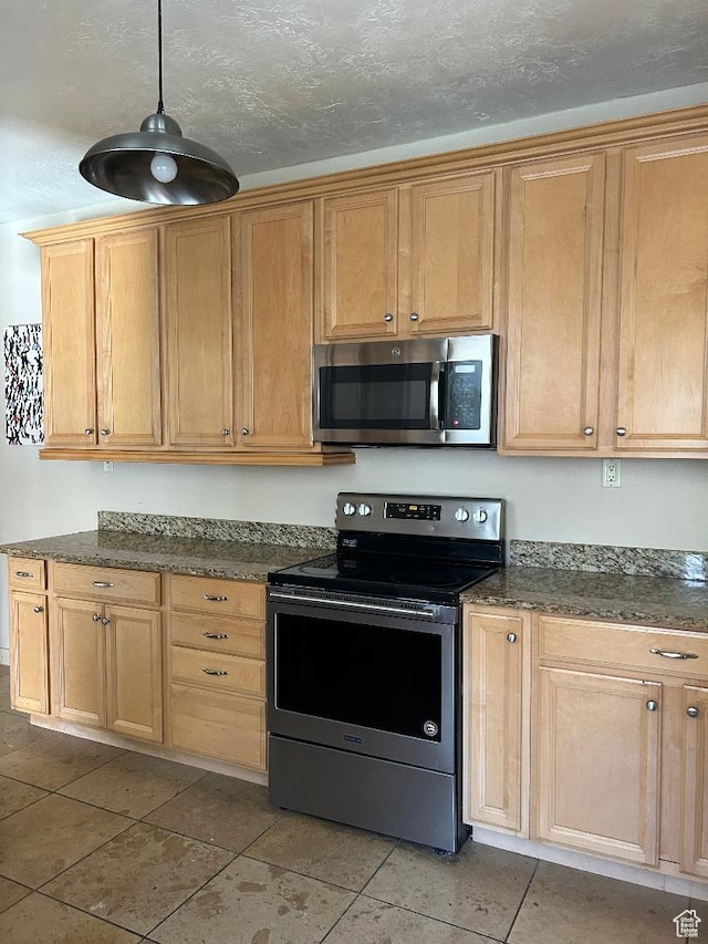 734 S 1300 E, Salt Lake City, UT 84102 - kitchen featuring stainless steel appliances, light tile patterned flooring, pendant lighting, and dark stone countertops