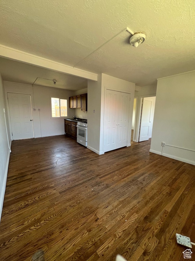 374 S 900 W, Cedar City, UT 84720 - unfurnished living room featuring a textured ceiling, dark wood finished floors, and baseboards