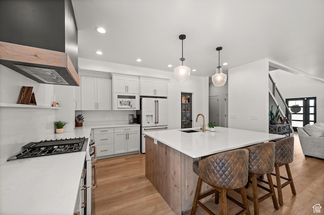 4681 W 75 N, West Point, UT 84015 - kitchen featuring wall chimney exhaust hood, a sink, white appliances, recessed lighting, and light wood-style flooring