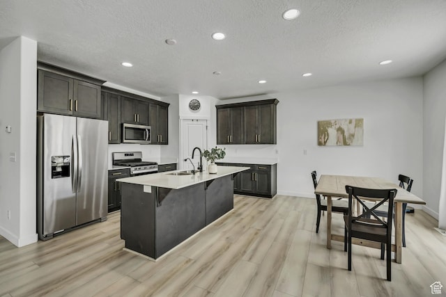 4214 E Sun Crest Dr Unit Lot68, Eagle Mountain, UT 84005 - kitchen with stainless steel appliances, a sink, light wood-style flooring, light countertops, and a kitchen island with sink