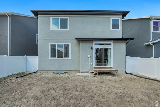 4214 E Sun Crest Dr Unit Lot68, Eagle Mountain, UT 84005 - back of house featuring stucco siding, a fenced backyard, and entry steps