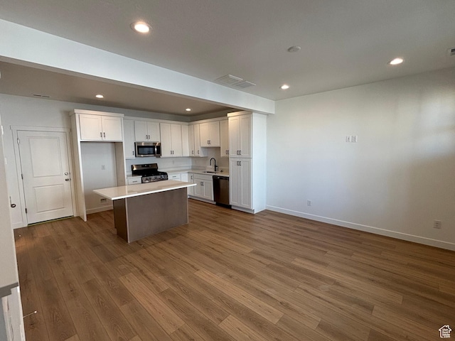 6889 W S Jordan Pkwy, South Jordan, UT 84009 - kitchen featuring appliances with stainless steel finishes, a sink, white cabinetry, dark wood finished floors, and baseboards