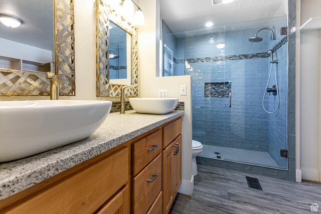 3380 S 930 W, Syracuse, UT 84075 - bathroom with wood finished floors, double vanity, a stall shower, and toilet
