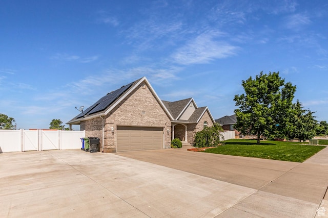 3380 S 930 W, Syracuse, UT 84075 - traditional-style home with a gate, brick siding, roof mounted solar panels, driveway, and an attached garage