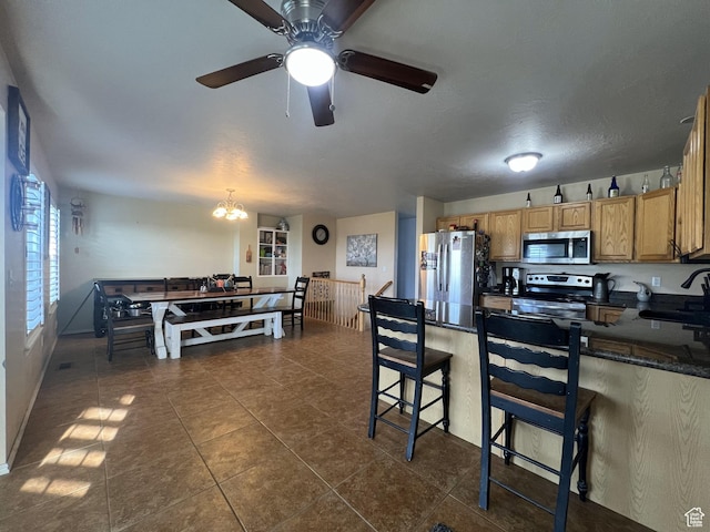 865 E 980 N, Tooele, UT 84074 - kitchen with stainless steel appliances, a chandelier, a sink, dark tile patterned flooring, and a ceiling fan